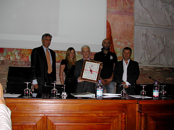 Il Presidente dell'istituto Grappa Piemonte Alessandro Revel Chion consegna il riconoscimento alla memoria di Romano Levi alla delegazione neivese.