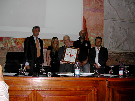 Il Presidente dell'istituto Grappa Piemonte Alessandro Revel Chion consegna il riconoscimento alla memoria di Romano Levi alla delegazione neivese.
